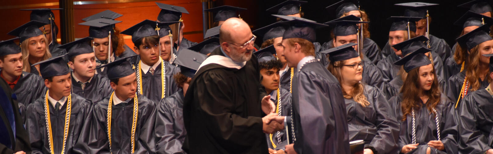 President, Phil Riley, shaking hands with Xavier High School graduate