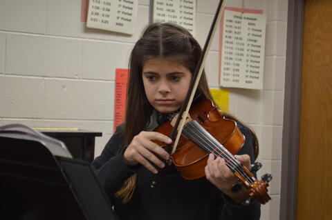 Xavier Middle School student playing violin in Orchestra