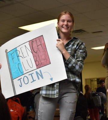 XHS Student holding Xavier French Club Sign
