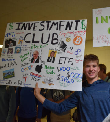 XHS Student holding Xavier Investment Club sign
