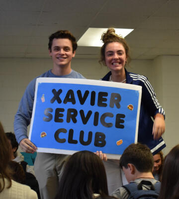 XHS Students holding Xavier Service Club sign
