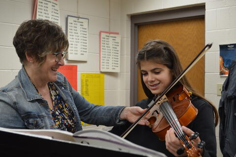 Xavier Middle School Orchestra teacher working with student